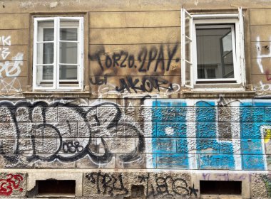 Ljubljana, Slovenya - 06 Temmuz 2025: Renkli grafiti, canlı bir şehir ortamında kentsel sanat ve kültürel ifadeyi vurgulayarak, açık pencereli yıpranmış bir duvarı kaplıyor
