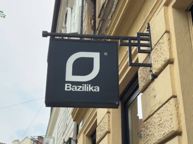 Ljubljana, Slovenya - Temmuz 06, 2025: Bazilika işareti, çağdaş tasarım ve kentsel mimarinin altını çizerek binanın üzerinde belirgin bir şekilde sergileniyor