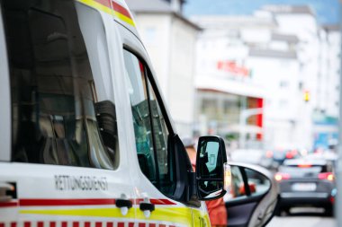 Villach, Avusturya - 11 Temmuz 2025: Ambulans yoğun bir caddede, yoldan geçen araçlarla kent ortamında acil durum müdahalesini vurguluyor