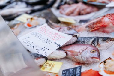 Villach, Avusturya - 11 Temmuz 2025: Pazar yerinde taze deniz ürünleri pazara sunuldu, fiyat etiketli balıklar ve alışverişçiler için canlı renkler sunuldu