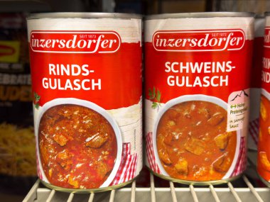 Villach, Avusturya - 10 Temmuz 2025: Konserve Inzersdorfer Rinds-Gulasch ve Schweins-Gulasch süpermarket raflarında sergilenerek, canlı ambalaj ve mutfak mirasını ön plana çıkardı