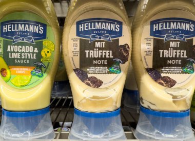 Villach, Avusturya - 10 Temmuz 2025: Hellmann 'ın raftaki sosları arasında avokado limon ve trüf mantarı aromaları yer alıyor, yemekler ve mutfak yaratıcılığını geliştirmek için mükemmel