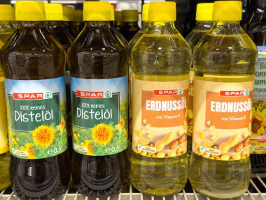 Villach, Avusturya - 10 Temmuz 2025: Spar marka yemek yağları bir süpermarket rafında renklendirici etiketli Damıtılmış yağ ve Fıstık yağı ile düzgünce düzenlenmiştir