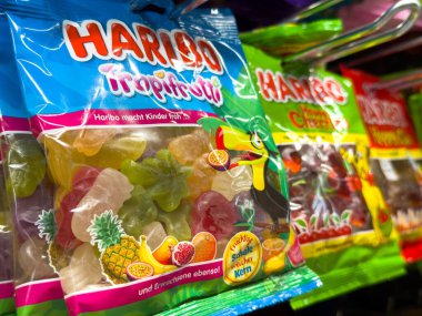 Villach, Avusturya - 10 Temmuz 2025: Haribo Tropifrutti şekerleme paketi rafta, renkli meyve şekilleri ve şeker severler için cazip bir tasarım yer alıyor