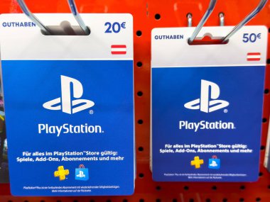 Villach, Avusturya - 10 Temmuz 2025: PlayStation hediye kartları perakende gösteriminde belirgin bir şekilde yer almakta, değer seçeneklerini ve oyunculara hitap eden tasarım