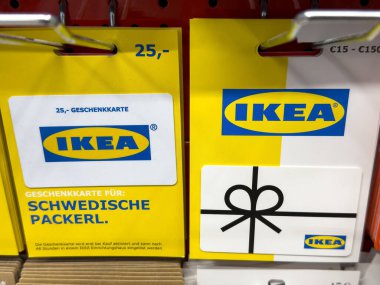 Villach, Avusturya - 10 Temmuz 2025: IKEA hediye kartları perakende rafında belirgin bir şekilde sergileniyor, parlak renkler ve alışverişçiler için cazip tasarımlar yer alıyor