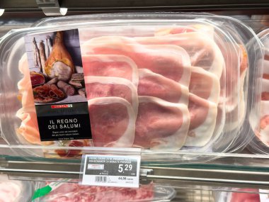 Villach, Avusturya - 10 Temmuz 2025: Bir süpermarkette dilimlenmiş et paketleri, açık bir kapta pişirilmiş jambon ve salam çeşitleri sergileniyor