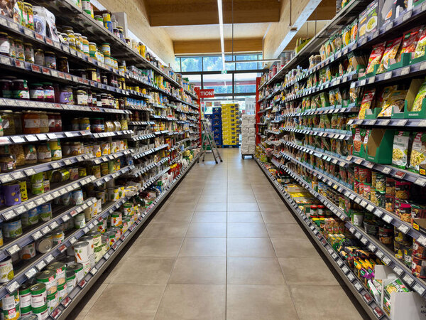 Villach, Austria - July 10, 2025: Grocery aisle displays a wide range of canned goods and products, with bright lighting enhancing the shopping atmosphere