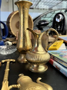 Villach, Avusturya - 12 Mayıs 2024: Antika pirinç vazolar ve dekoratif parçalar bit pazarında düzenlenir, eşsiz dokuları ve sanatsal ayrıntıları vurgulanır