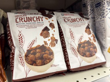 Villach, Avusturya - 15 Temmuz 2025: Çikolatalı gevrek paketleri bir rafta güzelce düzenlenmiştir, lezzetli görünüşleri ve çıtır çıtır dokuları ön plana çıkmıştır.