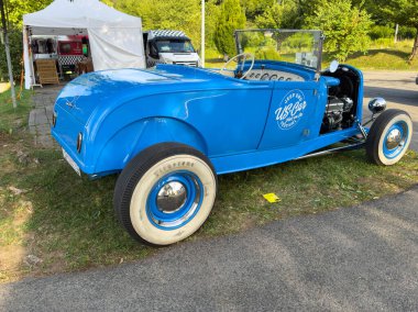 Villach, Avusturya - 20 Temmuz 2025: Klasik mavi araba bir etkinlikte açık havada park edilmiş, klasik tasarımını ve güneşin altındaki parlak rengini vurguluyor