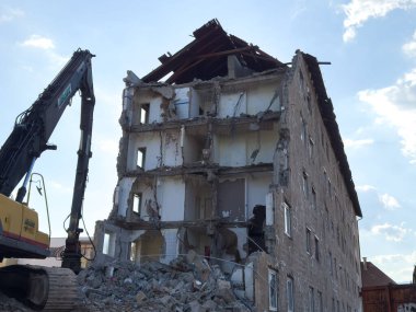 Arnoldstein, Avusturya - 20 Temmuz 2025: Ağır makineli çok katlı bir binanın yıkım süreci, olay yerindeki enkaz ve yapısal unsurları ortaya çıkarıyor