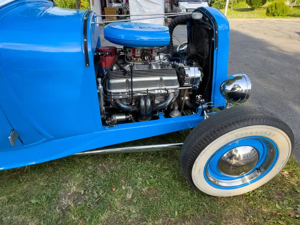 Villach, Avusturya - 20 Temmuz 2025: Mavi otomobil parlak bir motor ve krom aksanlı, çimlerin üzerine park edilmiş, klasik otomotiv tasarımı ve işçiliği sergilenmektedir