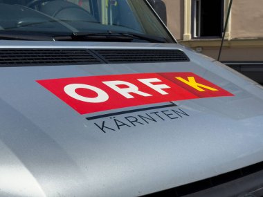 Villach, Avusturya - 24 Temmuz 2025: ORF Karnten logosu, bölgesel medya varlığını ve markasını temsil eden gümüş renkli bir aracın önünde açıkça görülüyor