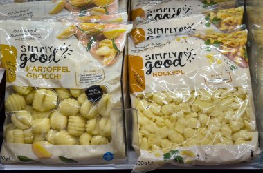 Villach, Avusturya - 24 Temmuz 2025: Basit olarak iyi patates gnocchi paketleri, uygun yemek seçeneklerini vurgulayarak, bir market dondurucusunda düzenlenir