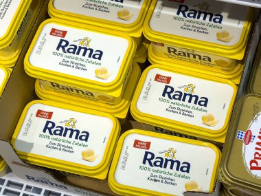 Villach, Avusturya - 24 Temmuz 2025: Rama tereyağı kapları bir bakkalda sergileniyor, parlak sarı ambalajları ve kolay görülebilirlikleri vurgulanıyor