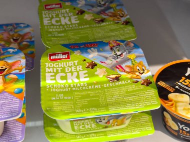 Villach, Avusturya - 24 Temmuz 2025: Muller yoğurt kabı renkli çizgi film karakterleri ve çikolata yıldızları aroması sergiliyor, perakende satış ortamında çocuklar ve ailelere hitap ediyor