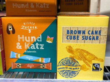 Villach, Avusturya - 24 Temmuz 2025: Vibrant Wiener Zucker şeker ambalajı Hund & Katz ve Brown Cane Cube Sugar 'ı perakende satış ortamında sergiliyor