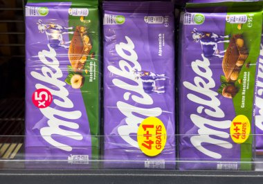 Villach, Avusturya - 24 Temmuz 2025: Milka çikolataları farklı tatlar ve cazip promosyonlar eşliğinde bir süpermarket rafına güzelce yerleştirilmiştir