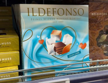 Villach, Avusturya - 24 Temmuz 2025: İldefonso nougat şekerleme kutusu çeşitli çikolata ve tatlılar sunuyor, bir mağaza rafında kalp motifleriyle güzelce dizayn edilmiş.