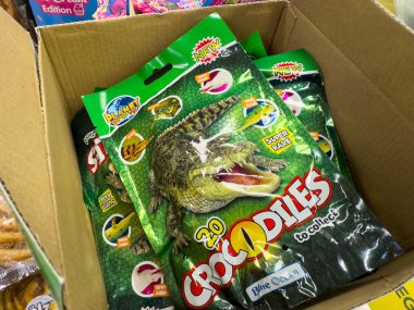 Villach, Avusturya - 24 Temmuz 2025: Çocuklar için parlak renkler ve eğlenceli grafiklerin yer aldığı, karton bir kutuda toplanabilir timsah oyuncağı paketi