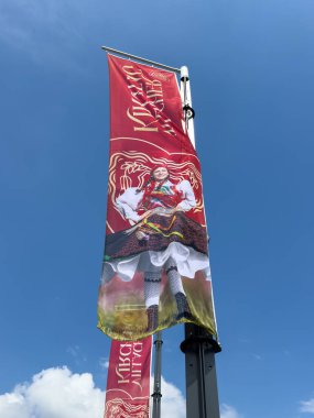 Villach, Avusturya - 24 Temmuz 2025: Canlı pankart, kültürel gurur ve şenlik atmosferini ön plana çıkaran Kötü Adam Kirchtag festivali için geleneksel giysiler sergiliyor