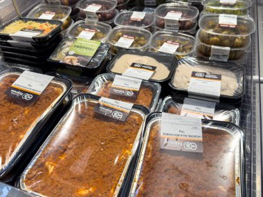 Tarvisio, İtalya - 26 Temmuz 2025: Markette hazır yemek konteynerlerinin gösterimi, çeşitli mutfakların vurgulanması ve kolay yemek çözümleri için cazip paketleme