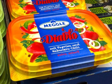 Villach, Avusturya - 28 Temmuz 2025: Paprika ve habanero biberli Meggle Diablo baharat serpiştirilmiş, parlak ambalajlı, özellikle market koridorlarında sergilenmektedir