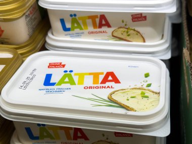 Villach, Avusturya - 28 Temmuz 2025: LATTA Orijinal yayılma ambalajı bir markette belirgin bir şekilde sergileniyor, taze malzemeleri ve canlı tasarımı vurgulanıyor