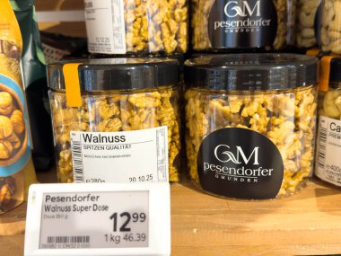 Villach, Avusturya - 28 Temmuz 2025: Pesendorfer ceviz kavanozları ahşap bir rafta düzenlenir, alışverişçiler için kalitelerini ve fiyatlarını vurgular