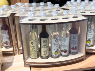 Villach, Avusturya - 28 Temmuz 2025: Ahşap tutacakta çeşitli İtalyan likörlerinin gösterimi, renkli etiketler ve çeşitli aromalar, hediye ya da kişisel koleksiyon için ideal