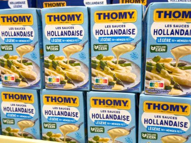Villach, Avusturya - 28 Temmuz 2025: Thomy Hollandaise sos kutuları rafta sergileniyor, renkli ambalajlar ve aşçılar için büyüleyici görüntüler vurgulanıyor