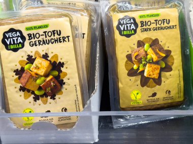 Villach, Avusturya - 28 Temmuz 2025: Billa süpermarketinde sergilenen vegan Tofu ürünleri, zeytinli tütsülenmiş çeşitleri sergiliyor, sağlıklı yiyecekler için mükemmel