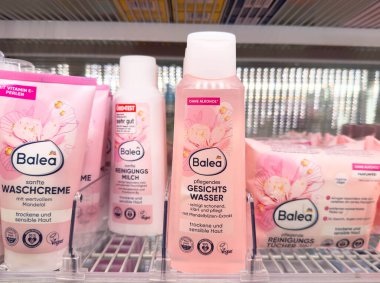 Villach, Avusturya - 28 Temmuz 2025: Perakende satışa sunulan ürünler arasında yumuşak krem, temizleyici süt ve hassas cilt için yüz suyu, çiçek ambalajı,