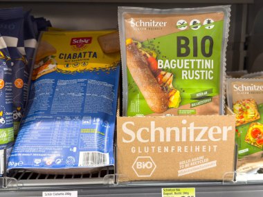 Villach, Avusturya - 28 Temmuz 2025: Schnitzer organik baget ambalajı süpermarket raflarında sergileniyor, glütensiz ve sağlıklı yeme seçenekleri vurgulanıyor