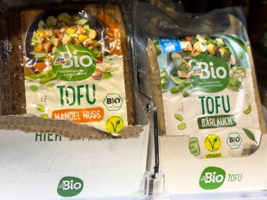 Villach, Avusturya - 28 Temmuz 2025: Tofu ürünleri rengarenk ambalajlı organik ve vejetaryen etiketlerini vurgulayan bir market rafına güzelce yerleştirilmiştir