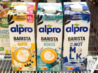 Villach, Avusturya - 28 Temmuz 2025: Alpro Barista bitkisel süt kutuları bir süpermarkette sergileniyor yulaf, hindistan cevizi ve süt seçenekleri değil