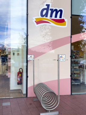 Villach, Avusturya - 30 Temmuz 2025: Parlak metal tasarımı, çevre dostu ulaşım ve kentsel yaşam tarzını destekleyen DM mağazasının önünde bisiklet rafı