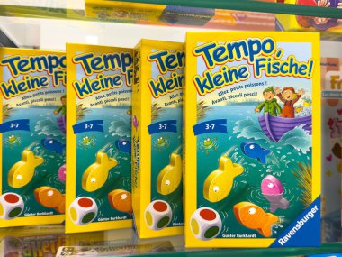 Villach, Avusturya - 30 Temmuz 2025: Tempo, Kleine Fische! Oyun kutuları canlı renkler içeren ve çocuklar için illüstrasyonlar içeren bir rafta düzenlenir