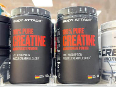 Villach, Avusturya - 30 Temmuz 2025: Vücut Saldırısı% 100 saf kreatin kavanozları bir fitness mağazasındaki bir rafta gösteriliyor, kaliteli spor malzemeleri vurgulanıyor