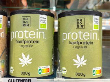 Villach, Avusturya - 30 Temmuz 2025: Naderia kenevir protein kutuları, organik ve vejetaryen özelliklerini ön plana çıkaran bir süpermarket rafında belirgin şekilde sergilenmektedir