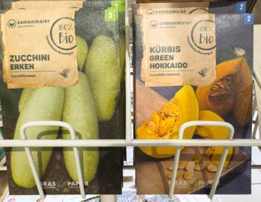 Villach, Avusturya - 30 Temmuz 2025: Kabak ve kabak için tohum paketleri organik bahçe seçeneklerini ve renkli tasarımları vurgulayan bir mağazada düzenleniyor