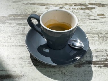 Kırsal masada Espresso bardağı ve güneş ışığı altında gölge..