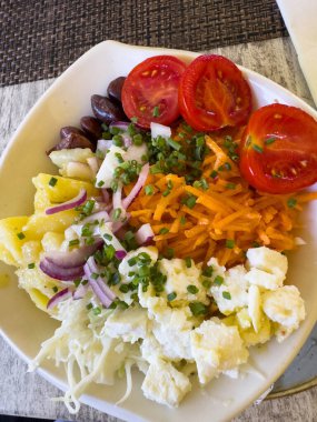 Beyaz kasede domatesli, peynirli, zeytinli ve sebzeli taze salata..