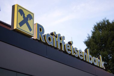 Velden, Avusturya - 18 Haziran 2025: Raiffeisenbank logosu binanın ön cephesinde görülüyor, markanın canlı kentsel ortamdaki varlığını vurguluyor