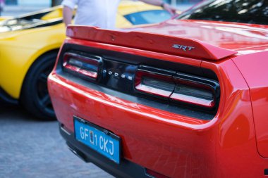 Velden, Avusturya - 18 Haziran 2025: Kırmızı Dodge SRT spor otomobili, çarpıcı tasarımını ve canlı bir açık hava ortamında canlı rengini sergileyerek Sportwagenfestival 'de belirgin bir şekilde sergilenmektedir.