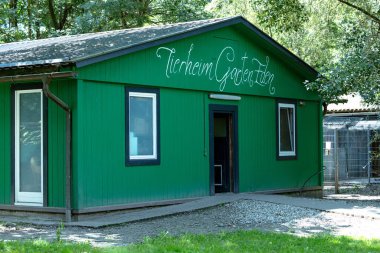 Klagenfurt, Avusturya - 01 Ağustos 2025: Yeşil Barınak Binası 'Tierheim Garten Eden' tabelası, çakıl yolu olan ağaçların arasına yerleşmiş, hayvanlar için davetkar atmosfer