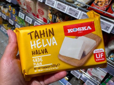 Villach, Avusturya - 15 Ağustos 2025: Koska tahini halva paketi, açık sarı rengini ve ürün bilgilerini bir market ortamında ön plana çıkardı