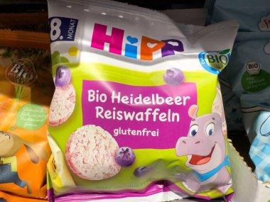 Villach, Avusturya - 15 Ağustos 2025: Yaban mersini aromalı HiPP organik pirinç kekleri, bebekler için glütensiz aperatif, neşeli bir hipopotam karakterli canlı ambalaj