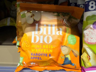Villach, Avusturya - 15 Ağustos 2025: Havuç ve elma aromalı Billa Bio mini pirinç kekleri, bir süpermarket rafında düzenlenmiştir.